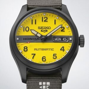 Close-up of a black Seiko Honda watch with a bright yellow dial, bold numerals, date window, gray strap, and sporty automotive design.