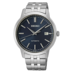 Silver Seiko automatic wristwatch on a black background, with a stainless steel bracelet, navy dial, luminous markers, and a date window at 3 o’clock; sleek, classic style.
